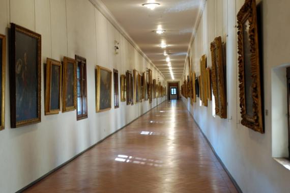 Un long couloir décoré de tableaux